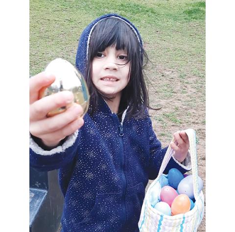 Photos by Anngee Quinones-Belian/Staff Correspondent  Six-year-old Hazel Beck of Peachtree found a golden egg during a hunt at High Lonesome Therapeutic Equestrian Center in Unaka on March 23. She said about finding the eggs, “I feel like it’s really easy because I can see them all.” She’ll be starting riding lessons at the center in April, riding atop Daniel.