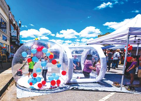 Sam Jokich/Staff Correspondent These youngsters at the Murphy Spring Festival on Saturday were happy trying to catch red and blue balloons inside an air-circulating plastic bubble. More photos, page 8A.