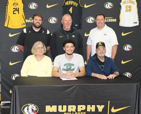 Photos by J.R. Carroll/Staff Correspondent Murphy’s Dominick Rummler signed with Piedmont University in Demorest, Ga. Dominick plans to get a degree in criminal justice. Pictured with Dominick are his parents, Beth (left) and Craig Rummler. Standing is Murphy basketball assistant coach Dawson Grizzle (left), head coach Eric Laney and assistant coach Andrew Skogen.