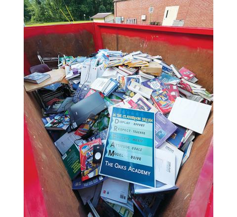 Randy Foster/editor@cherokeescout.com A Dumpster filled with textbooks and other classroom-related materials sits outside the former Oaks Academy/Marble Elementary School campus Monday. It has been mentioned as a possible new location for Central Office.