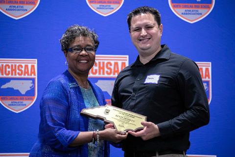 N.C. High School Athletic Association Commissioner Que Tucker (left) presents The Graham Star’s Kevin Hensley with the Tim Stevens Media Representative of the Year Award on June 12.