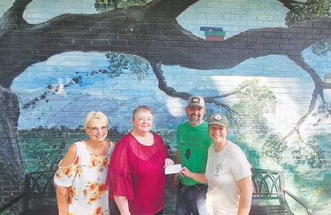 Photos by Nicole Wright/Staff Correspondent Owners Corey and Kam Thompson of Hoppy Trout Brewing Co. present Andrews Public Library branch co-managers Kelly Bryant and Jacqueline Hulse with their June fundraiser check from the “Round Up Your Change” drive. The brewery matched funds for a total of $600, their largest fundraiser so far to date in 10 months of ownership. From left are Bryant, Hulse, Corey Thompson and Kam Thompson.
