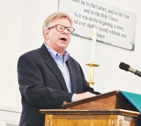 The Rev. Jonathan Hodges stands behind the pulpit at Murphy Presbyterian Church as their new pastor.
