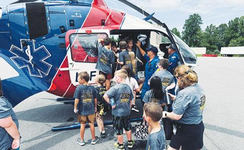 Photos by Randy Foster/editor@cherokeescout.com: Children swarm around LifeForce 6, a helicopter ambulance based at Western Carolina Regional Airport in Andrews, during STEM Camp at Tri-County Community College in Peachtree on Aug. 8.
