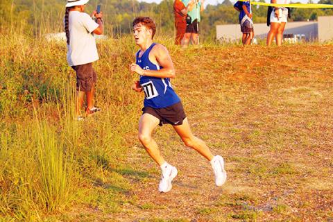 Cannon Crompton/sports@cherokeescout.com Ethan Russell of Hiwassee Dam runs down a small slope during the second cross-country meet of the season at Tri-County Early College in Peachtree on Aug. 28, winning his second straight meet.
