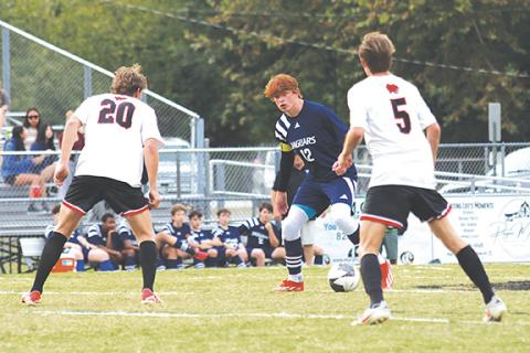 Cannon Crompton/sports@cherokeescout.com Tri-County’s Andrew White (middle) controls the ball as Ty Clark (left) and Gabe Clark (right) of Andrews defend on Sept. 11.