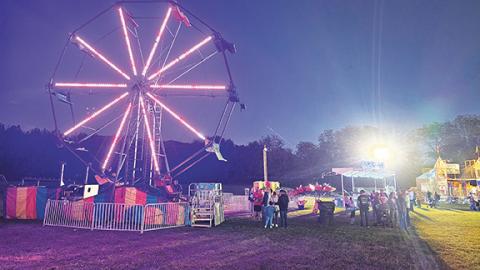 Nicole Wright/Staff Correspondent Eager crowds draw near the large, colorful Ferris wheel during the Cherokee County Fair in Andrews last weekend.