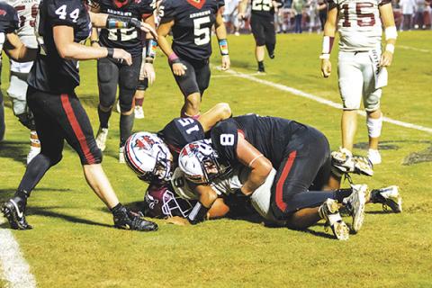 Photos by Cannon Crompton/sports@cherokeescout.com Kencade Watkins and Kelby Waldroup of Andrews tackle a Swain County player and prevent a first down Friday night at Hugh Hamilton Stadium.