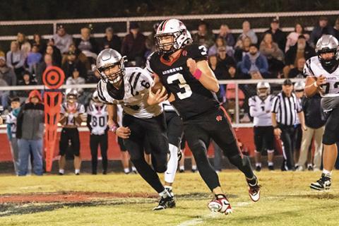 Cannon Crompton/sports@cherokeescout.com Andrews quarterback Everett Tatham runs past Robbinsville defenders to pick up yards during the game Friday night.
