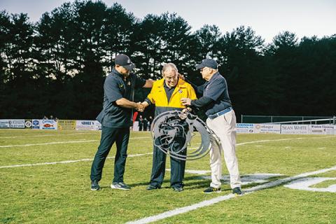 Andrew Zenobi/Contributing Photographer Murphy High School announcer J.R. Carroll (middle) gets a Bulldog sign from retired coach David Gentry (right). They are joined by Murphy High School athletic director and head football coach Joseph Watson (left).