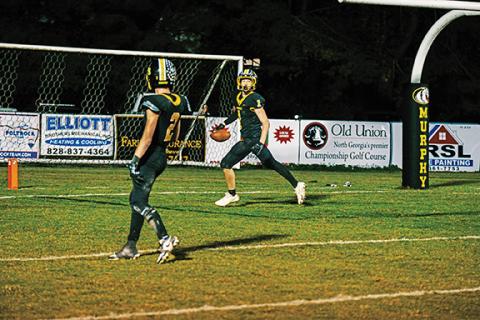 Andrew Zenobi/Contributing Photographer Kenyon Nichols of Murphy enters the end zone and looks back at Will Shore during their game against Swain County under the lights Friday night.