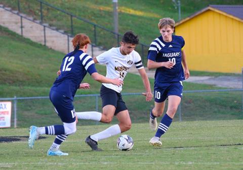 Photos by Cannon Crompton/sports@cherokeescout.com Elijah Twiggs (middle) of Murphy dribbles past defenders Andrew White (left) and Landen Spies (right) of Tri-County during their match Thursday. 