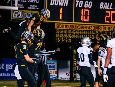 Andrew Zenobi/Contributing Photographer Janthony Gooden lifts up Will Shore after scoring a touchdown against Robbinsville in the third round of the NCHSAA 1A playoffs on Friday night.
