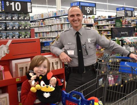 Anngee Quinones-Belian/Staff Correspondent  N.C. Highway Patrol Officer Chris Cook enjoyed spending shopping time with little partner Wyatt Patterson at a past Shop With a Cop event.