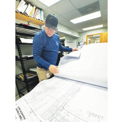Randy Foster/ editor@cherokeescout.com Cherokee County code enforcement official David Ricks sorts through half of about 50 pounds of site plans for an expansion project at Core Scientific in Marble on Monday.