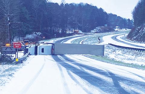 Vanessa Dills/Contributing Photographer A Federal Express truck lies on its side after slipping on fresh fallen snow along U.S. 64/74 in western Cherokee County on Friday. Driving was hazardous in many areas throughout the weekend.