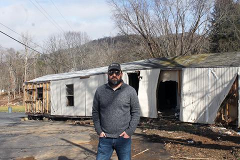 Dwight Otwell/Contributing Photographer Nick Smith, Murphy native and a coordinator of relief efforts for Hurricane Helene in western North Carolina, stands in front of one of the many devastated homes.