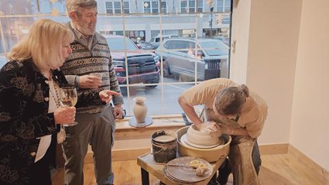 Holly and David Johnson (from left) look on as potter Chris Jones demonstrates his wheel techniques during the Cherokee County Arts Council’s inaugural Starry Night Gala fundraiser Saturday.