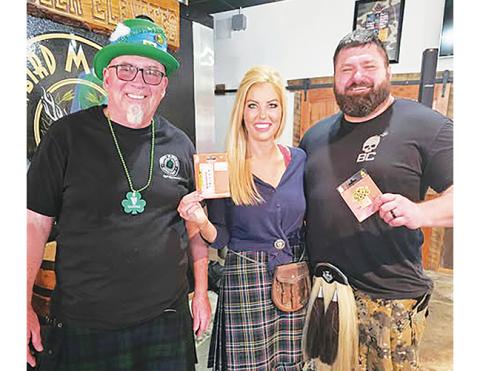 Nicole Wright/Staff Correspondent Snowbird Mountains Brewery hosted their second annual Andrews community St. Patrick’s Day celebration Saturday. Festivities included music by Bill Vespasian and Pop’s Big Cheese food truck offering traditional Irish fare along with a kilt contest. Winners were Casey and DJ Kerr, who claimed Home Depot gift certificates. From left are owner Terry Vaughan, Casey Kerr and DJ Kerr, a U.S. Army veteran. The Kerrs’ golden retrievers – Dolly and Gunner, replete with holiday bandan