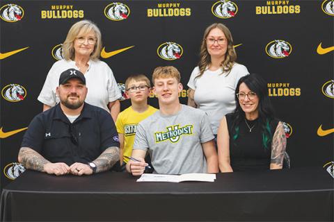 Cannon Crompton/ sports@cherokeescout.com Murphy senior Kenyon Nichols (middle, seated) signed a letter of commitment to continue his football career at Methodist University in Fayetteville on March 12. The Bulldogs tight end and outside linebacker was joined by (front row, from left), Bryan Nichols and Tristin Nichols. In the back row are Linda Bloom, Knox Nichols and Amy Nichols.