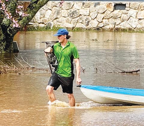 Randy Foster/editor@cherokeescout.com Owen Gibson carries a cat named Smoky that he rescued from a house on the banks of the overflowing Hiwassee River on Monday morning.