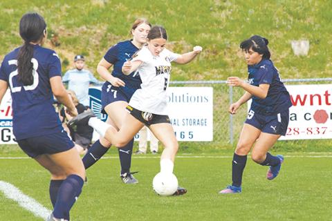 Cannon Crompton/sports@cherokeescout.com Ella Ledford (right) of Murphy takes a shot through Tri-County Early College defenders during their match Thursday.