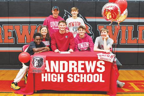 Cannon Crompton/ sports@cherokeescout.com Andrews High School senior basketball player Ty Clark (middle, seated) signed a commitment letter Thursday to continue playing basketball at Union University in Jackson, Tenn. While at Union, Clark plans on studying theology and Christian studies. Pictured with Ty are (seated, from left) brother Zeke Clark, mother Bethany Clark, brother Gabe Clark and brother Luke Clark. Standing (from left) are his father, Shawn Clark, and brother Levi Clark.