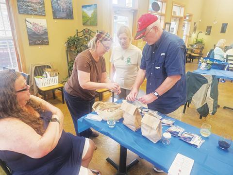 Photos by Nicole Wright/Staff Correspondent Sheila Hudson (left) and Megan Lambert (right) along with owner Jan Olson (middle) offer gardening advice to Roy Blackwell (far right) along with seeds and plant starts at the Cherokee Clay Food Alliance Seed Swap on April 6 at FernCrest Winery in Andrews.