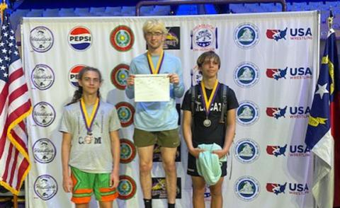 Rex Cable/Contributing Photographer Chase Beasley (right) of Andrews stands on the podium after his second-place finish Saturday.