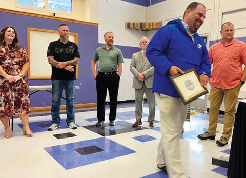 Randy Foster/editor@cherokeescout.com Cherokee County Schools Principal of the Year for 2024-25 is C.J. Rummler of Hiwassee Dam Middle School (foreground) it was announced Thursday night. Cherokee County Board of Education members Steve Coleman, Jeff Tatham, Arnold Mathews, Jeannie Gaddis (behind Rummler) and Jason Murphy are from left.