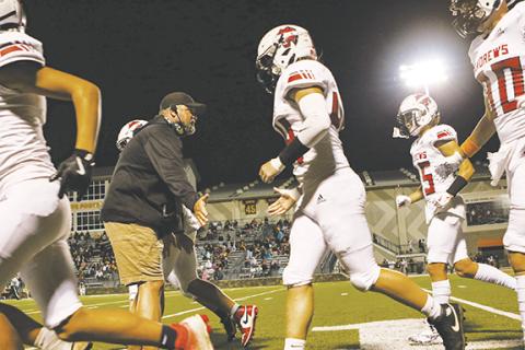 Cannon Crompton/sports@cherokeescout.com Former Andrews Wildcats varsity head football coach James Phillips high fives his players as they run onto the field to take on Cherokee on Oct. 10, 2024.