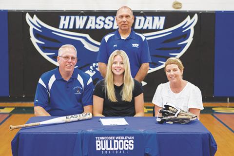Cannon Crompton/ sports@cherokeescout.com Olivia McNabb (middle, seated) of Hiwassee Dam signed a letter of commitment to play softball at Tennessee Wesleyan University in Athens, Tenn. She signed the letter on May 21 with family, coaches, teammates and friends in attendance. She plans on majoring in elementary education for physical education. McNabb was joined by her father, Chad McNabb (left, seated), mother, April McNabb (right, seated) and Tennessee Wesleyan softball head coach Toby Brooks (standing).