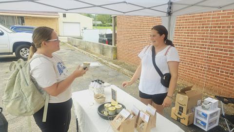 Photos by Nicole Wright/Staff Correspondent: Katie Colontonio (right) of Golden Herbals gets feedback from repeat customer Skye Raxter (left) at the Andrews Farmers Market’s opening day Friday. The market is open from noon-4 p.m. Fridays at the old A&P parking lot downtown.