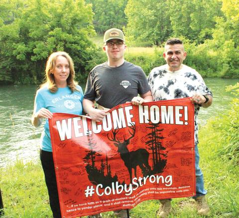 Photos by Stacy Van Buskirk/Staff Correspondent From left, the Oxtons – Bonnie, Colby and Cullen – show one of the signs made when Colby returned home after recovering in the hospital from a gunshot. The family was welcomed by neighbors and friends March 22.