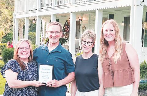 Photos by Nicole Wright/Staff Correspondent Andrews Chamber of Commerce Executive Director Shannan Kelly (left) presents the Business of the Year award to Morning Fog Coffee & Eats during the Andrews Chamber of Commerce’s annual awards dinner June 10 at the historic Walker Inn. With Kelly (from left) are co-owners Curt Steinlage, wife Leslie and daughter Sydney.