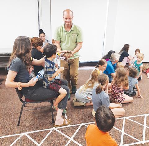 Photos by Anngee Quinones-Belian/Staff Correspondent Tom Bennett was happy to walk around the room letting kids at the Murphy Public Library pet his big brown toad, Trevor.