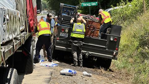 Randy Foster/editor@cherokeescout.com Fuel leak: Responders work to contain a diesel fuel leak after road debris punctured a big rig’s fuel tank along U.S. 64 West near Harvest Oaks Drive around lunchtime June 5. Responders set up barriers to keep leaking fuel from reaching Caney Creek and the Nottely River watershed. The driver was not at fault, according to officials at the scene.