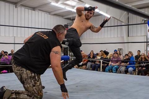 Cannon Crompton/sports@cherokeescout.com Flex Ferguson lands a kick on Mountain Man Jeremy Stiles during the American Championship Wrestling Federation’s event in January.