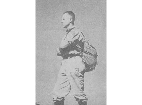 Jesse Nicholls is standing at the edge of a cliff on Tusquittee Trail in search of high elevation salamanders for his scientific experimentation. It was reported that his left foot was in Clay County, and his right foot was in Macon County when this photo was made.