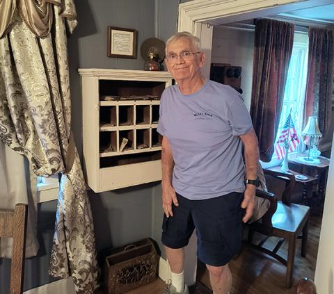 William Pitt Walker III, great-great-grandson of Squire William Walker and Margaret Scott Walker, is standing by the Valleytown Post Office inside The Walker Inn.