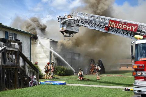 Firefighters pour water on fire at a four-unit apartment complex in Tomotla on Monday.