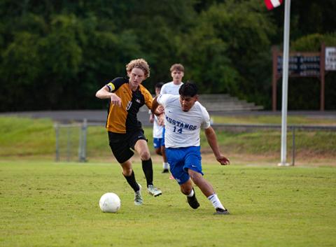 Michelle Bradbeer/Staff Correspondent Murphy Bulldog Tyler Payne (left) fights off a Smoky Mountain player during their soccer match on Aug. 11.