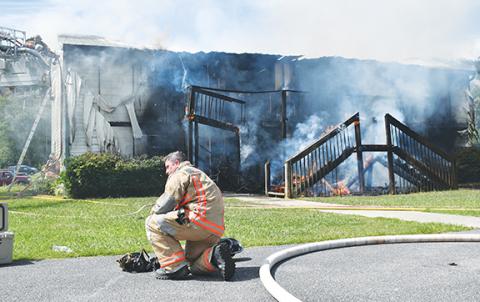 Photos by Randy Foster/editor@cherokeescout.com A firefighter catches his breath during a two-story building blaze at Meadowbrook Apartments on Aug. 26.