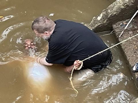 Photos by John Altenbernd/Contributing Photographer The Rev. Tim Huff of Murphy Free Methodist Church baptizes Johnny Walker into Christ on Aug. 2 in the Valley River, as church members watch from the nearby bridge. While the water isn’t as clear as it used to be, many folks say getting baptized in the river outside in nature brings them a greater sense of spiritual peace.