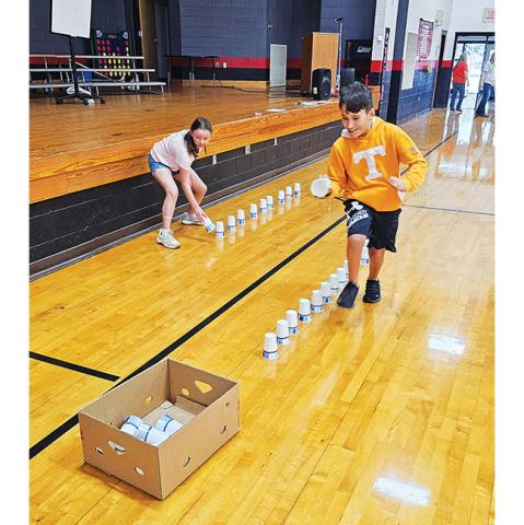 Photos by Nicole Wright/Staff Correspondent Janna Stewart (left) and Grayson Cutshaw duel it out in the Cup Race during Andrews Elementary School’s Score Big With Math & Reading Family Night on Oct. 16. The evening featured both mental and physical feats for prizes for students. Parents in attendance also enjoyed seeing their children’s progress so far in the school year.