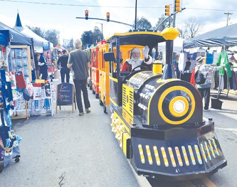 Photos by Anngee Quinones-Belian/Staff Correspondent Above: A train horn alerted festival goers to a passing trackless train driven by Santa along Main Street in downtown Andrews on Saturday. Below: The crowd remained steady throughout Christmas on Main.