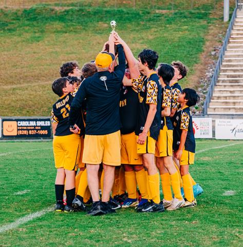 Katina Zenobi/Contributing Photographer The Murphy Middle School boys soccer team hoists the Smoky Mountain Conference championship trophy after their win over Cherokee on Nov. 5.