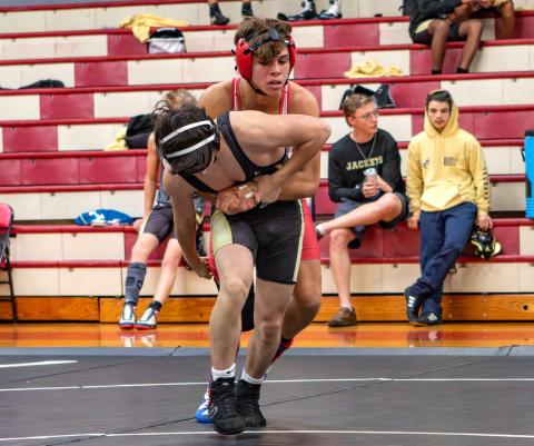 Cannon Crompton/sports@cherokeescout.com Chase Beasley (red and white singlet) takes on Braxten Gibson of Hayesville during the Wild West Duals in Andrews on Nov. 26. 