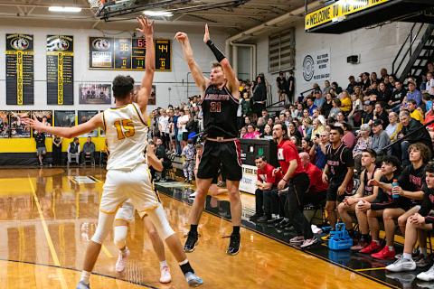 Ty Clark (right, No. 21) shoots a 3-pointer while Abram Twiggs (left, No. 15) of Murphy defends on Feb. 13.