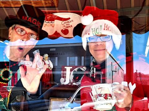 Anngee Quinones-Belian and Donna Duval entertain passersby on Dec. 20 as living mannequins in the window of Marketplace Antiques on Peachtree Street in downtown Murphy.